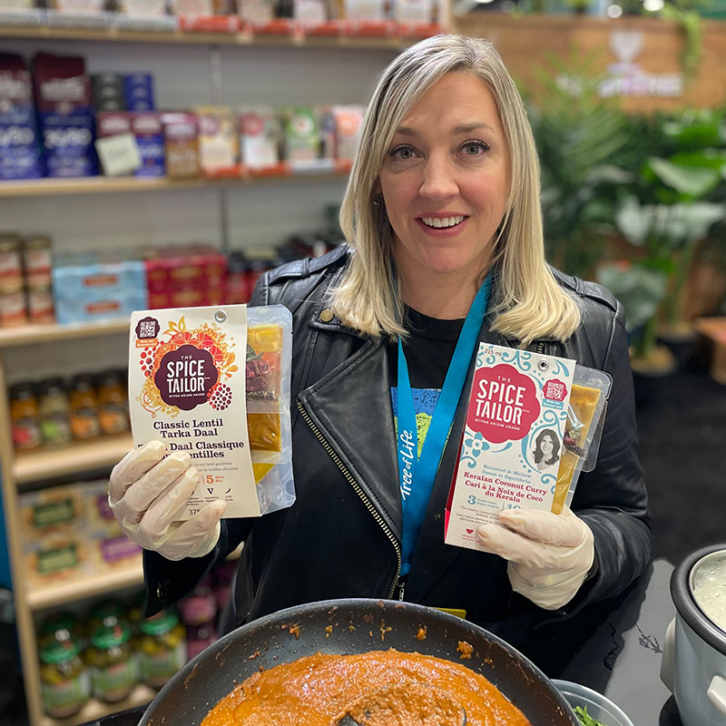 A blonde woman holding two Spice Tailor packages