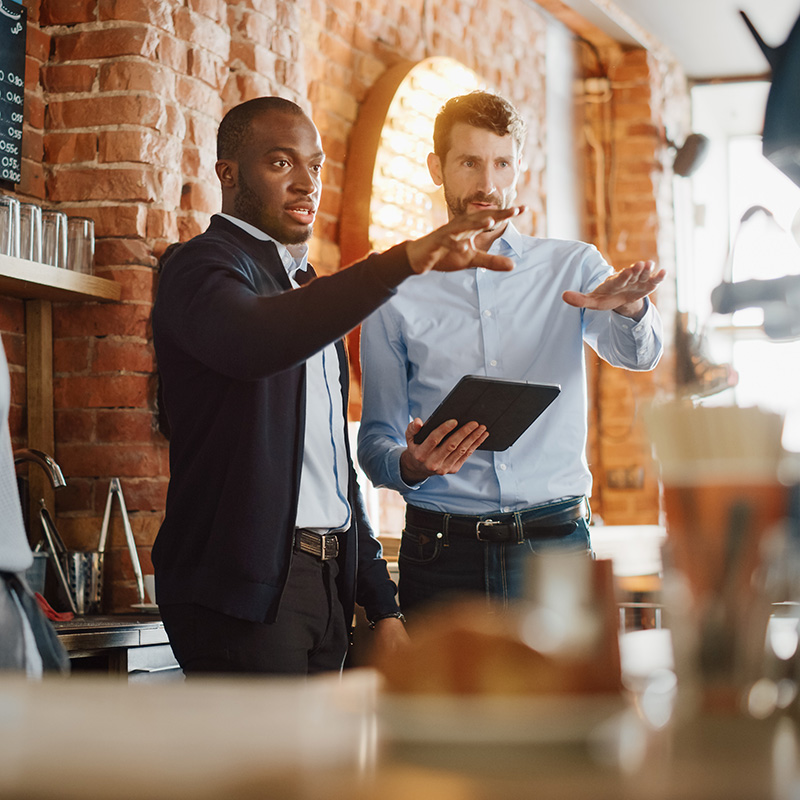 Two men discussing inventory in a restaurant