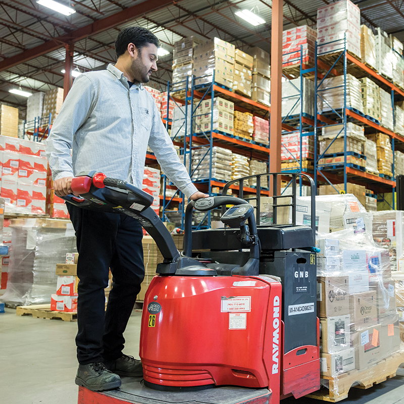 A man using a skidsteer in a warehouse